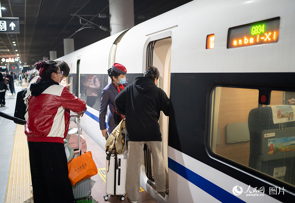 2025年春運首日，深圳北站，乘務員協助旅客登車。人民網 江佳玲攝