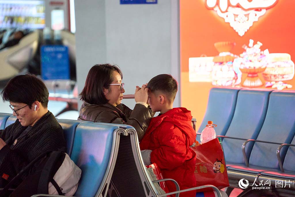 1月13日 太原南站，母親幫孩子整理頭發。人民網 張超寧攝