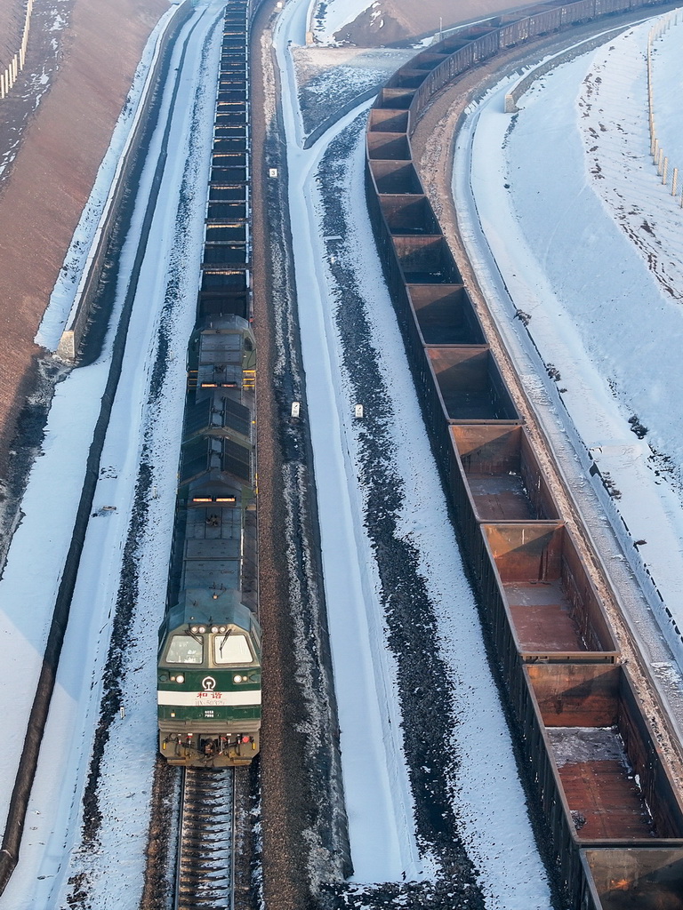 在新疆準東經濟技術開發區內的新疆宜化礦業有限公司煤炭裝車環線，一列出疆的貨運列車在進行裝煤作業（1月20日攝，無人機照片）。