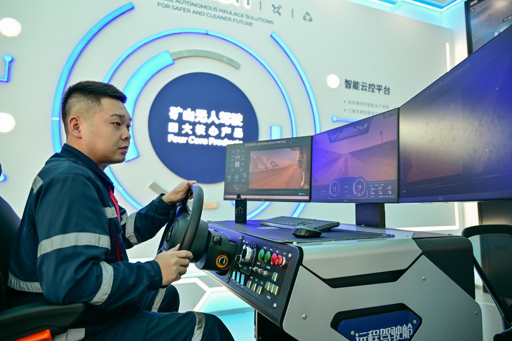 在新疆準東經濟技術開發區內的新疆宜化礦業有限公司五彩灣礦區一號露天煤礦，工作人員手握方向盤時刻準備介入遇到突發情況的無人駕駛車輛（1月20日攝）。