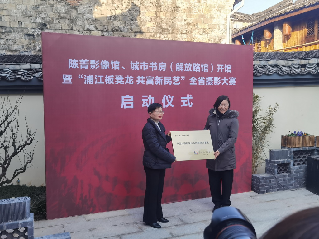 中國女攝影家協會副主席趙迎新向浦江縣文聯黨組書記、主席朱婉華授予“中國女攝影家協會教育培訓基地”牌匾。