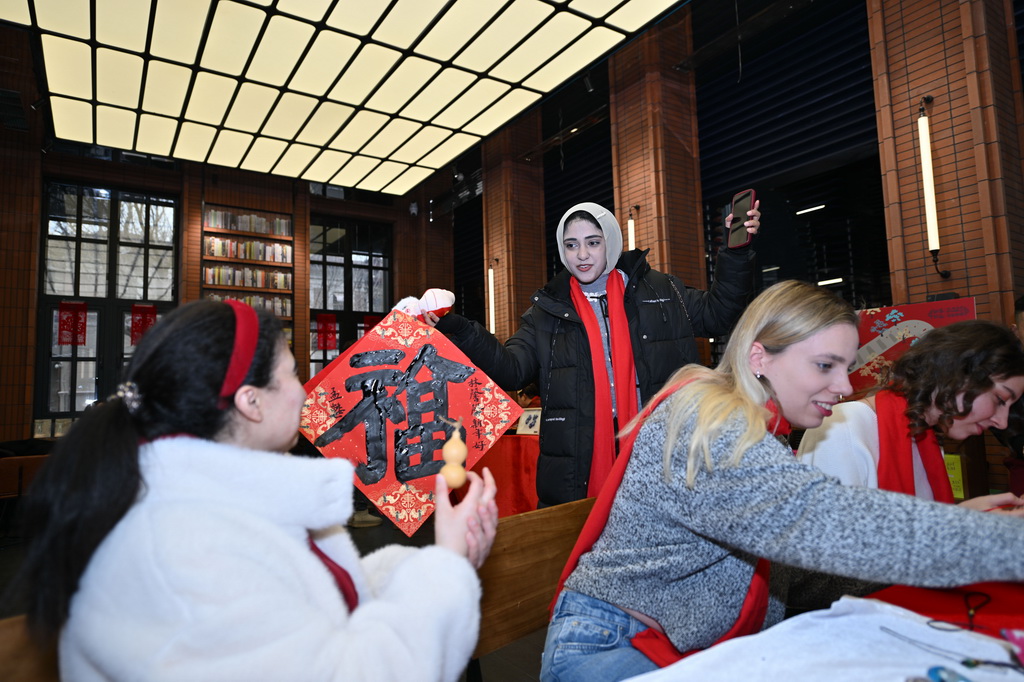 1月26日，留學生在天津意式風情區鐘書閣書店展示福字。