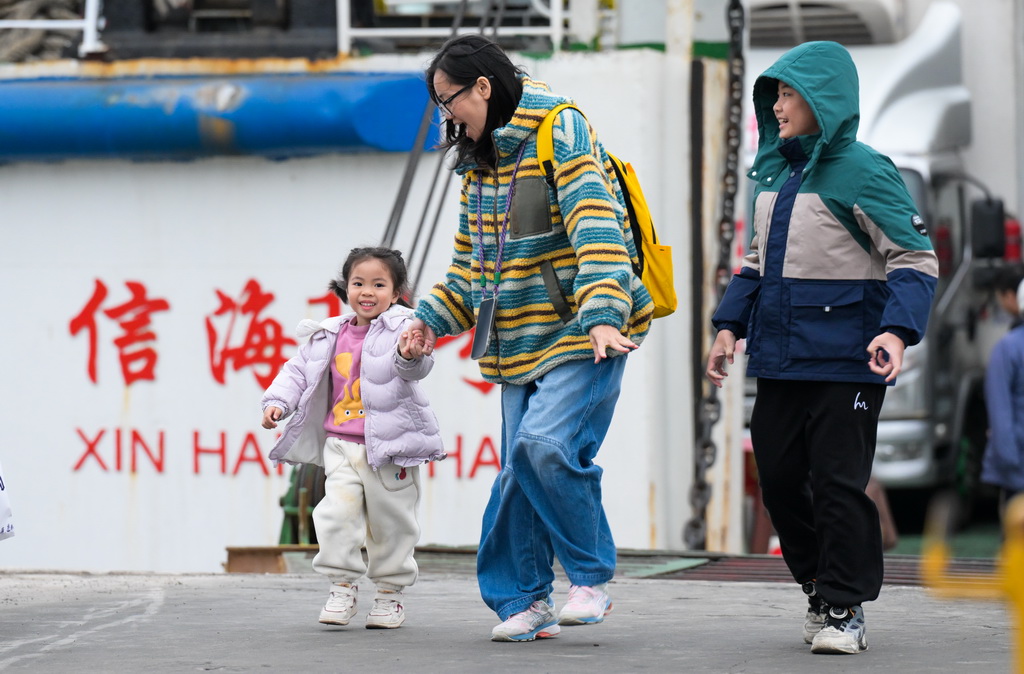 1月26日，在海南省?？谑行阌⒏?，旅客走下客滾船。