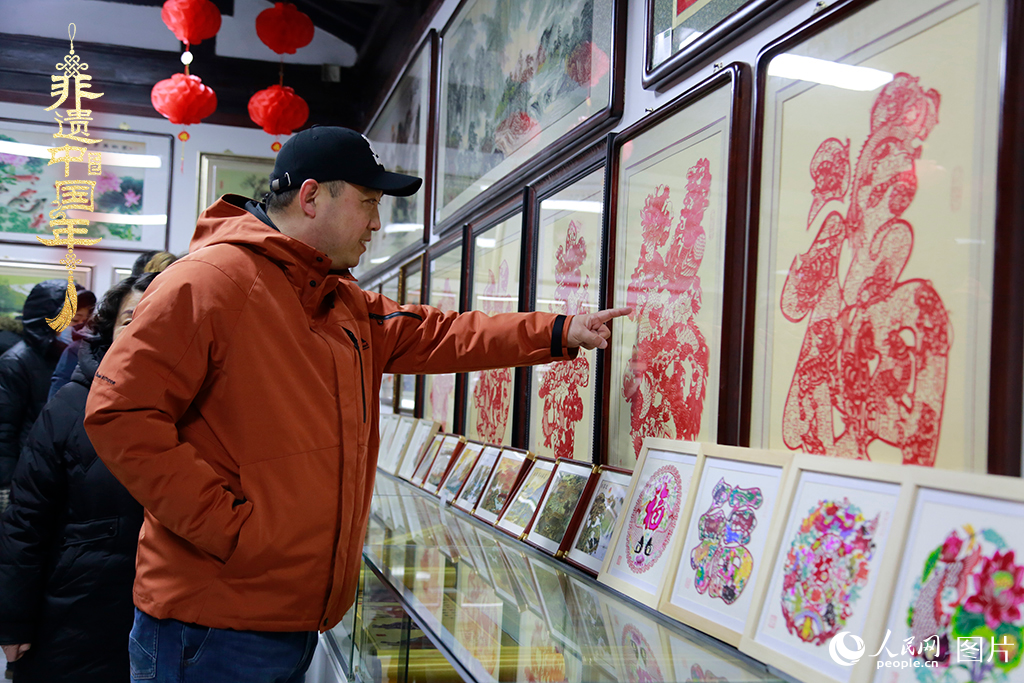 2025年1月23日，游客在天津楊柳青古鎮欣賞傳統剪紙作品，感受指尖上的古老藝術。人民網記者 崔新耀攝