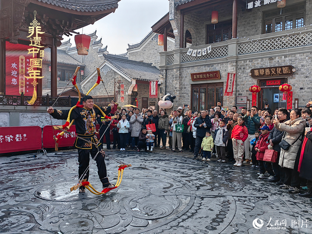 2025年1月29日，湖北襄陽市管家巷，老北京天橋大刀張舉大刀拉硬弓第五代傳承人現場表演，一次拉開6張弓，引來游客喝彩。人民網記者 郭婷婷攝