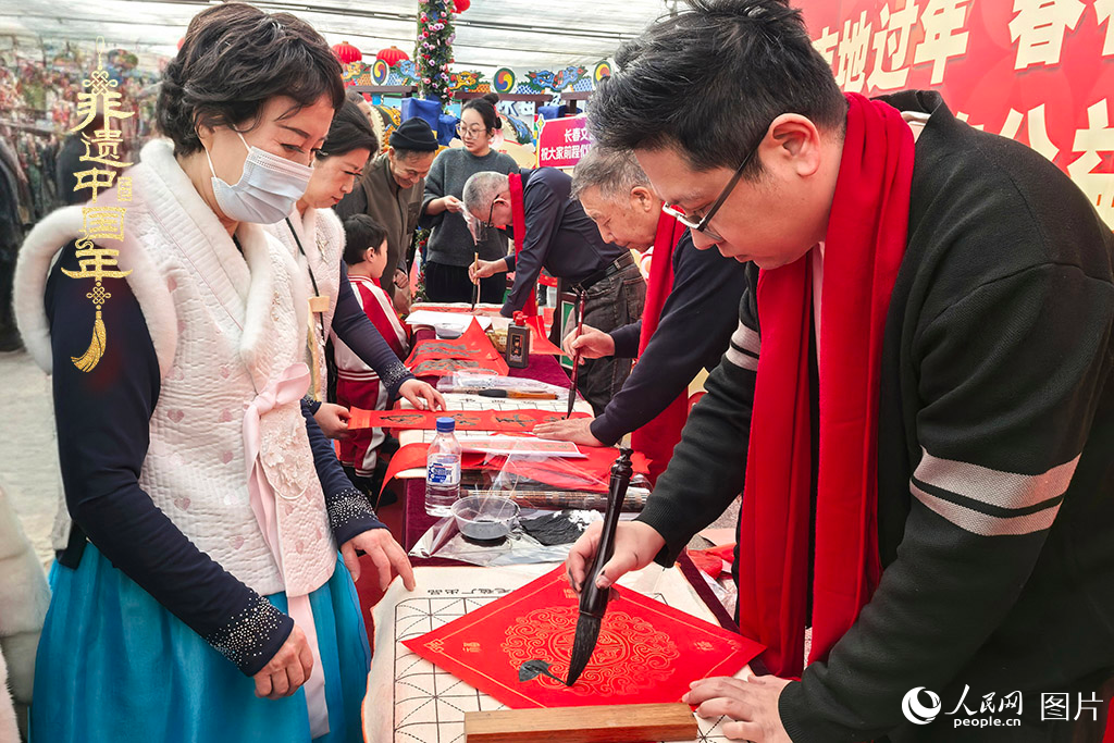 新春佳節之際，長春農博園冬季展會火熱進行，展廳內，書法家現場書寫“?！弊?，市民游客紛紛上前迎春接“?！?。人民網記者 王海躍攝
