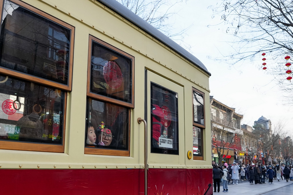 1月29日，在位于北京中軸線上的前門大街，游客乘坐“鐺鐺車”觀光游覽。新華社記者 鞠煥宗 攝