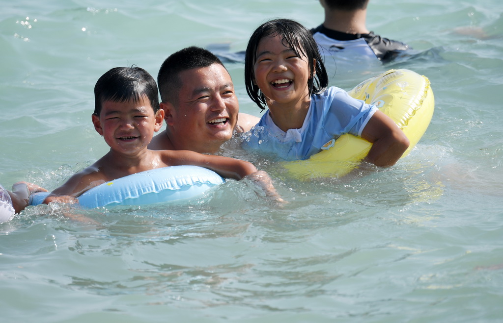 2月6日，游客在三亞市大東海景區游泳。