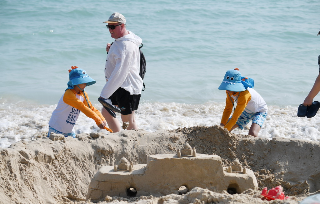 2月6日，游客在三亞市大東海景區沙灘上堆城堡。