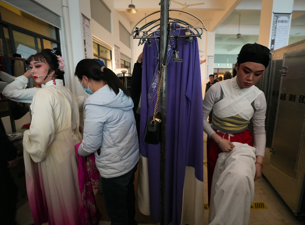 在浙江紹興嵊州市三界鎮清水塘村文化禮堂，下鄉演出的嵊州市越劇團演員在臨時隔出的區域補妝、更衣（1月21日攝）。