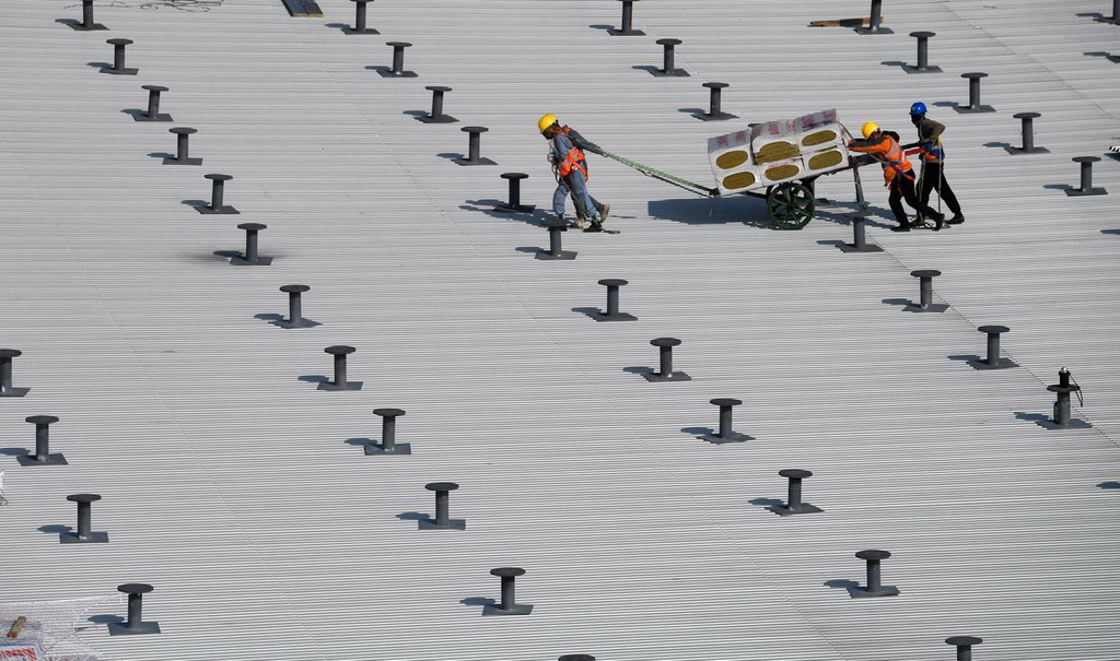 2月9日，在三亞鳳凰國際機場三期改擴建項目施工現場，工人在T3航站樓鋼結構屋頂施工。