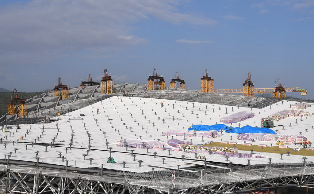 2月9日，在三亞鳳凰國際機場三期改擴建項目施工現場，工人在T3航站樓鋼結構屋頂施工。