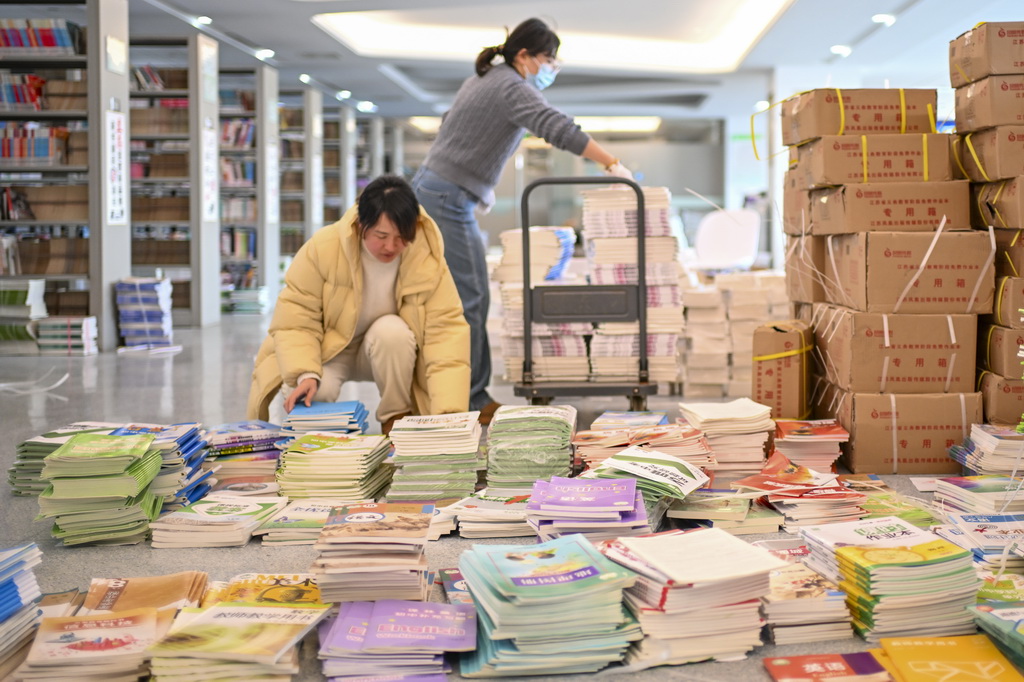 2月10日，江蘇省昆山開發區青陽港學校的老師在清點、整理新學期教材。新華社發（王須中攝）
