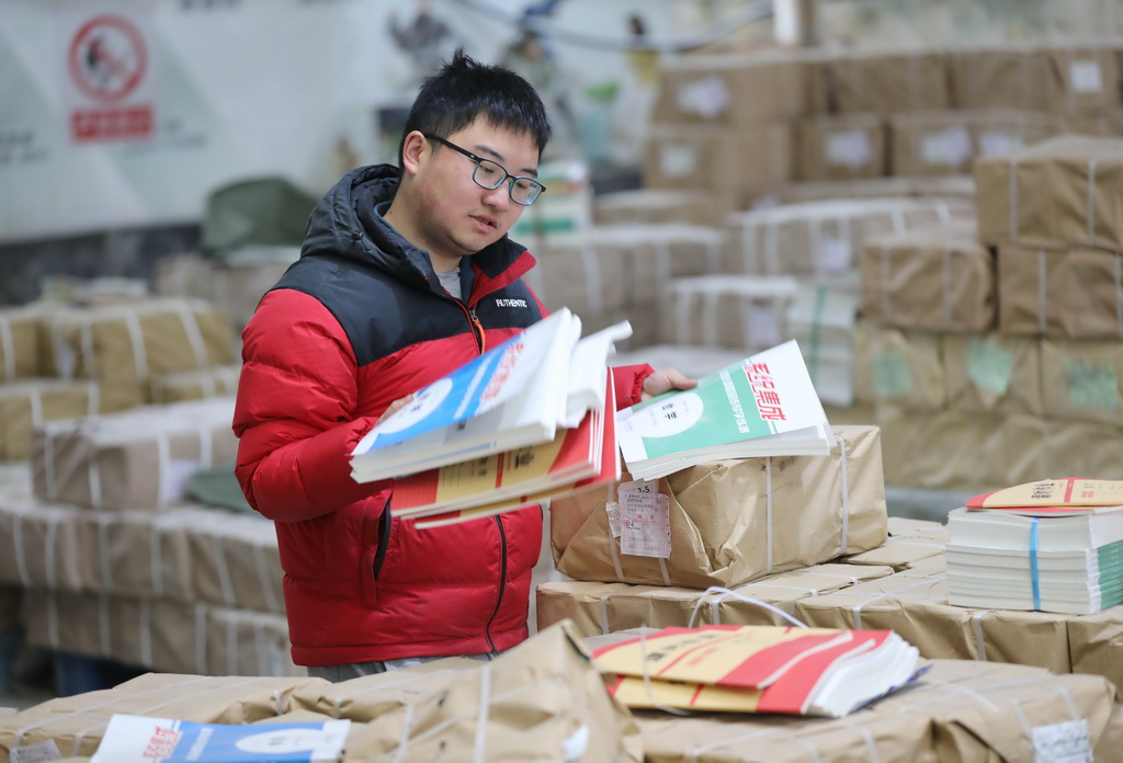 2月10日，在湖南省永州市道縣新華書店倉庫，工作人員在清點、分發教材。新華社發（何紅福攝）