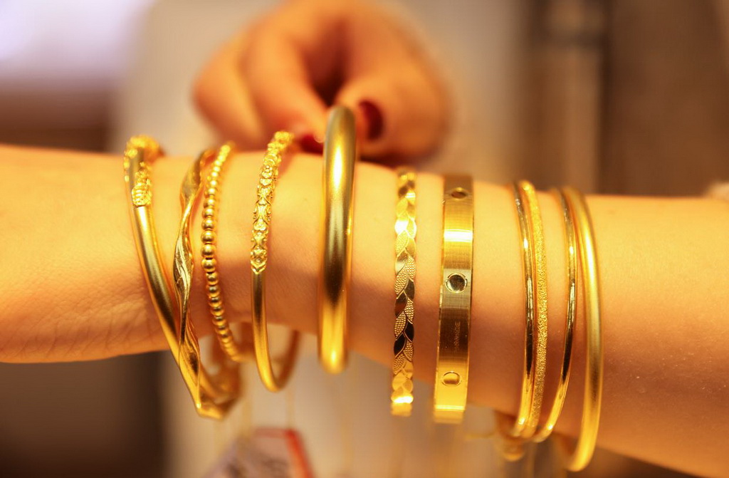 2月11日，在浙江省湖州市德清縣乾元鎮一家金店，店員展示黃金首飾。