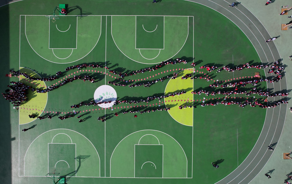 2月26日，石家莊市草場街小學學生在觀賞龍頭蜈蚣風箏（無人機照片）。新華社發（閆志國攝）