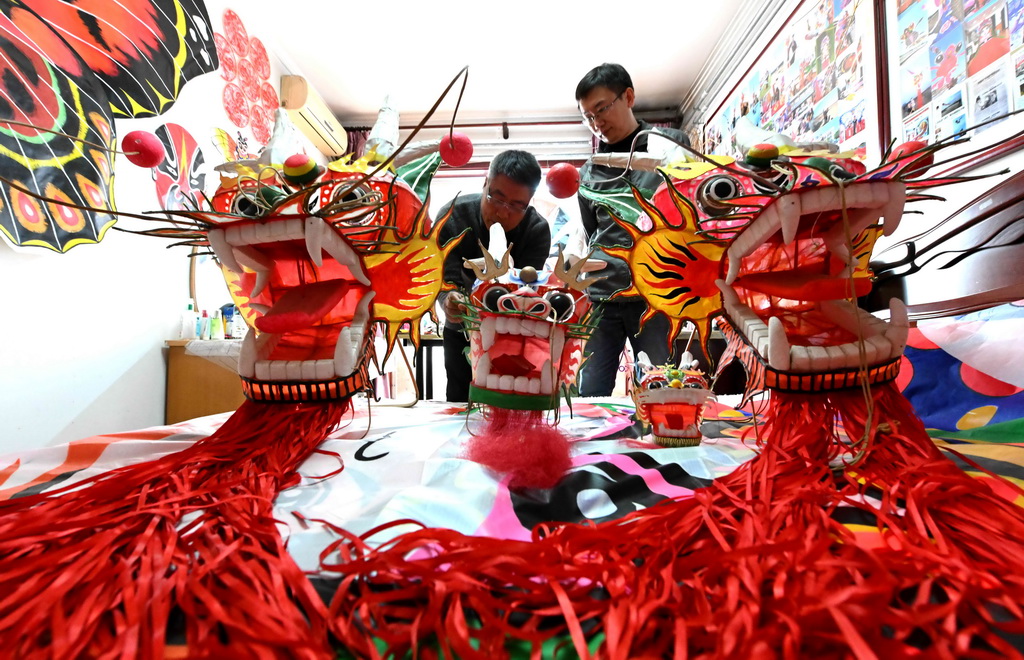 2月26日，王彥州（左）在石家莊市家中制作龍風箏。新華社發（陳其保攝）