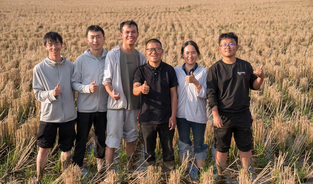 2月27日，青年教師黃光福（右三）與學生在多年生稻科技小院的試驗田間合影。