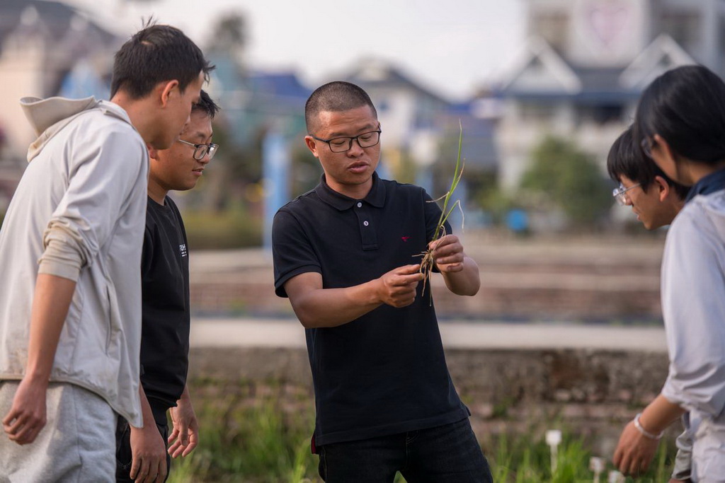 2月27日，青年教師黃光福（中）在試驗田間給學生授課。