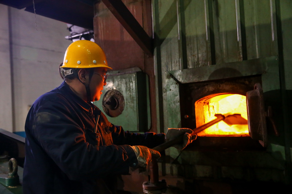 3月2日，山東省濟南熱電集團有限公司金雞嶺熱電廠工人檢查供暖設備燃燒情況。新華社發（郝鑫城攝）