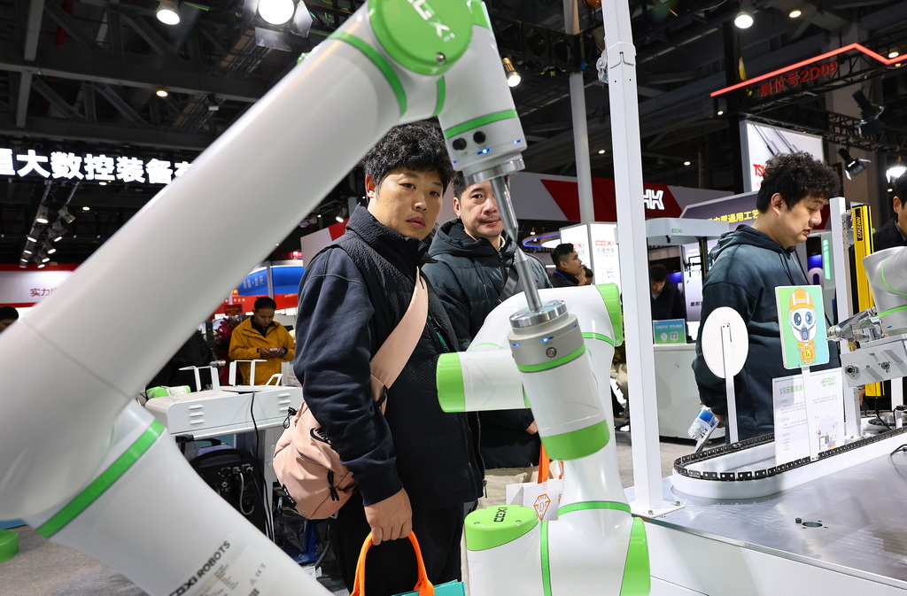 3月3日，參觀者在一個進行作業演示的雙臂協同機器人前駐足觀看。