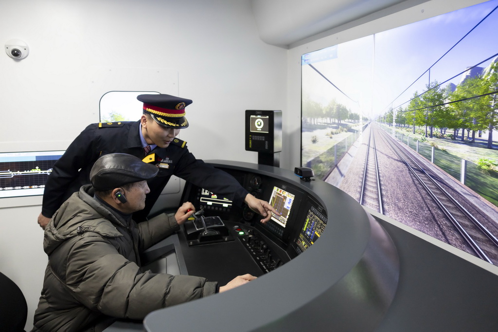 3月4日，第一代“周恩來號”機車組成員、首發副司機王蘇生（前）在“周恩來號”機車展室體驗模擬駕駛。