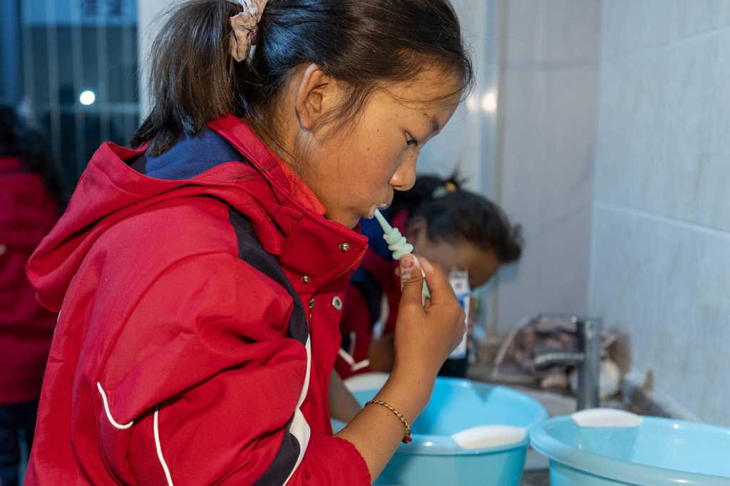 3月5日，來自受災最嚴重的定日縣長所鄉、措果鄉、曲洛鄉的3所小學的學生在定日縣委黨校分流安置點洗漱。