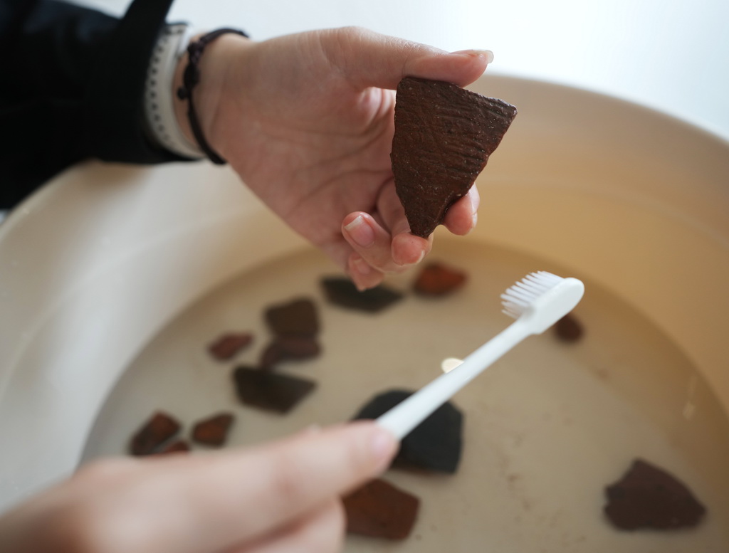 3月11日，在遼寧省朝陽市北票市的考古人員住所，考古人員在清洗調查現場發現的碎陶片。新華社記者 李鋼 攝