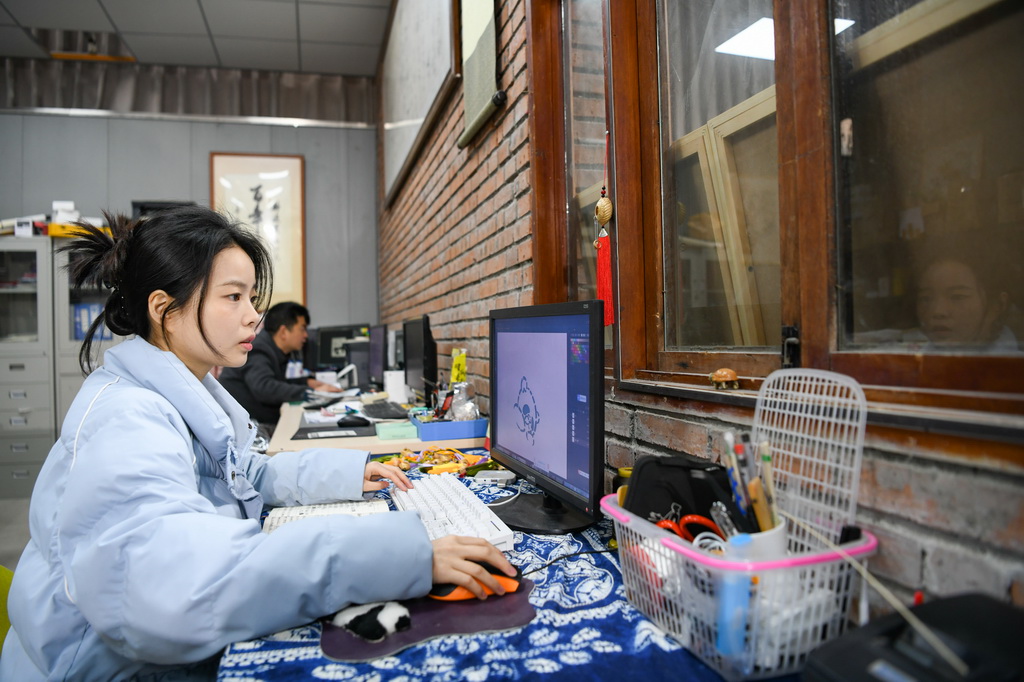 白梓憶（前）在電腦上設計完善熊貓文創形象細節（3月7日攝）。新華社記者 王曦 攝