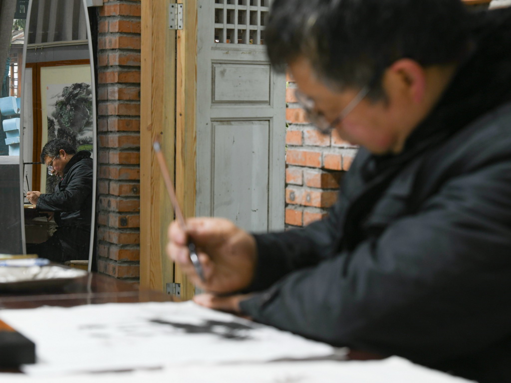 崇州皮影戲非物質文化遺產傳承人楊勇在繪制“熊貓抱竹”設計草圖（3月6日攝）。新華社記者 王曦 攝