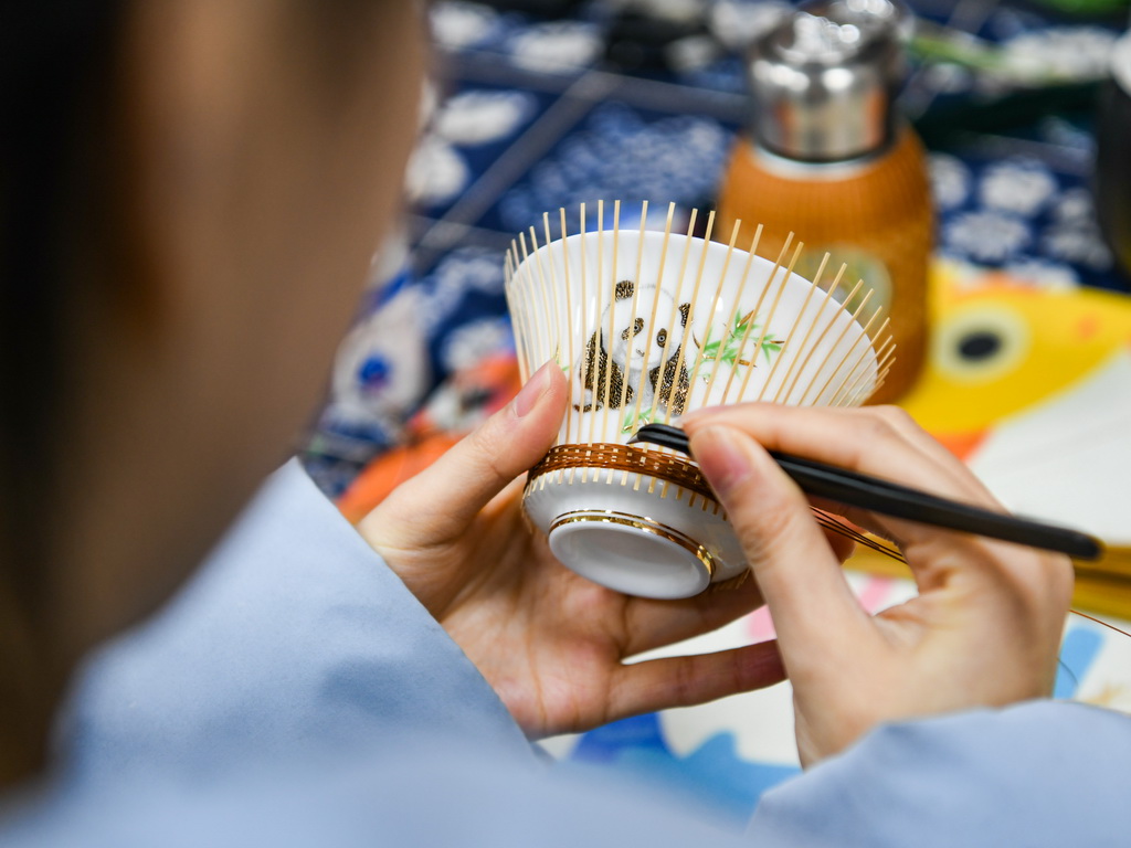 白梓憶在編制“熊貓抱竹”蓋碗茶杯（3月7日攝）。新華社記者 王曦 攝