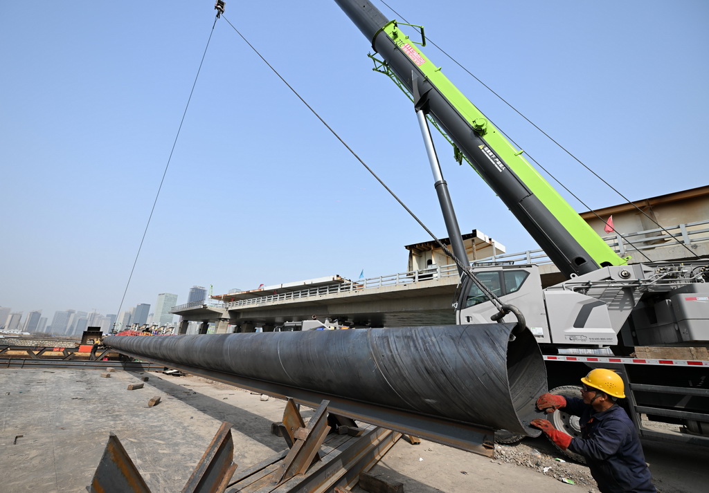 3月13日，在位于天津市濱海新區的于新橋施工現場，起重設備吊裝圍堰鋼管樁。