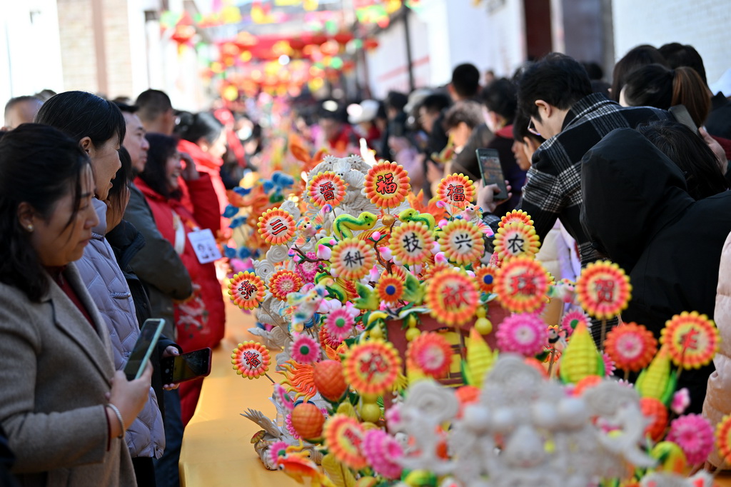 3月18日，在山西省嵐縣嵐城鎮，人們欣賞面塑作品。