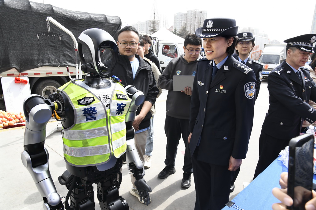 3月24日，一名女警官與警用機器人進行語音交流演示。