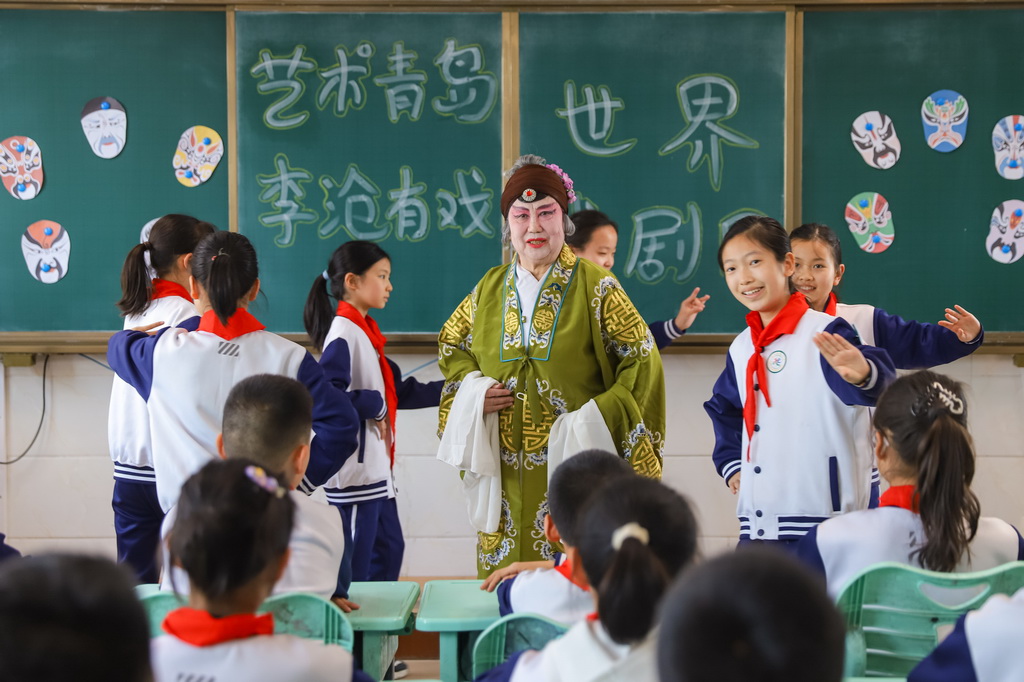 3月25日，在山東青島北山小學開展的“藝術青島·李滄有戲”主題活動中，柳腔演員指導學生戲曲動作。新華社發（張鷹攝）