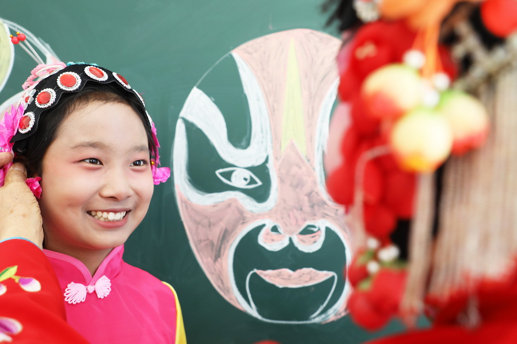 3月25日，在河北省唐山市豐潤區泉河頭鎮團山子小學，評劇演員幫助學生整理頭飾。新華社發（朱大勇攝）