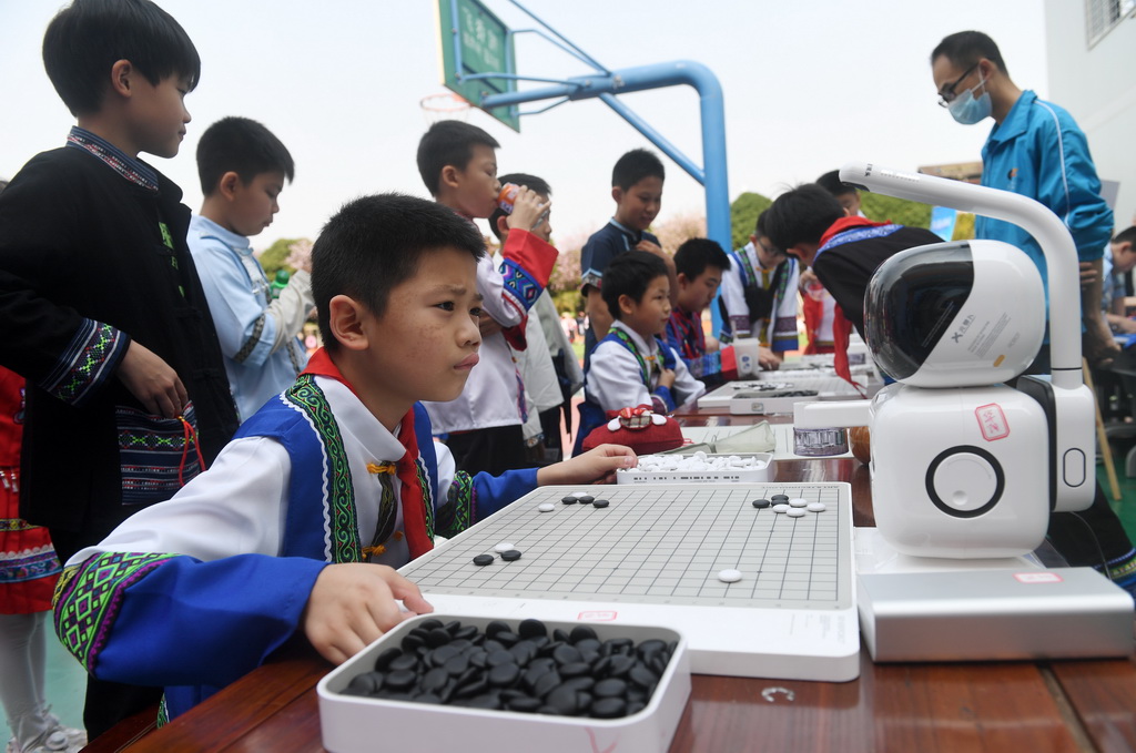 3月27日，在廣西南寧市濱湖路小學，學生在和機器人下圍棋。新華社記者 陸波岸 攝