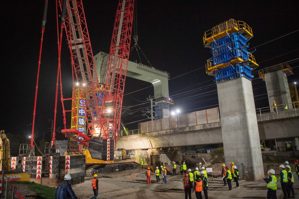 3月27日，在成達萬高鐵建設現場，施工人員在進行高鐵鋼橫梁吊裝作業。新華社記者 唐奕 攝