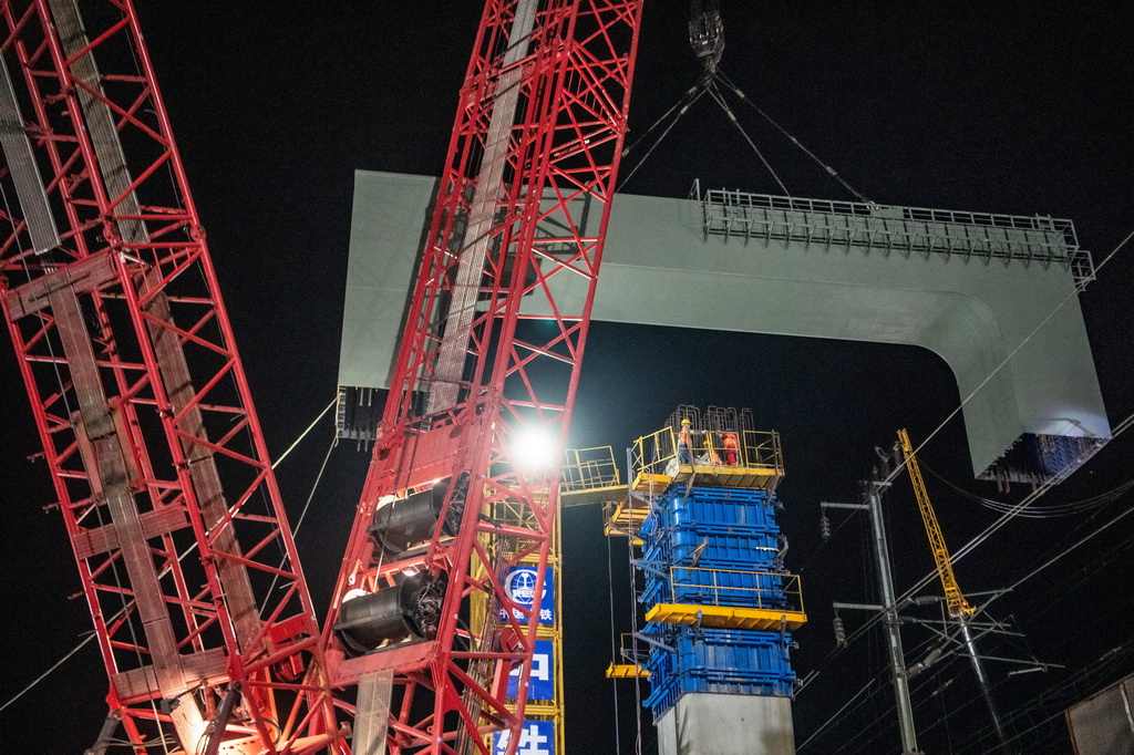 3月27日，在成達萬高鐵建設現場，施工人員在進行高鐵鋼橫梁吊裝作業。新華社記者 唐奕 攝