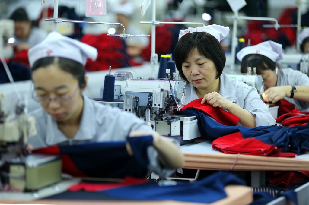 3月30日，山東省青島市即墨區即發集團有限公司的員工在生產出口到海外的服裝產品。新華社發（梁孝鵬攝）