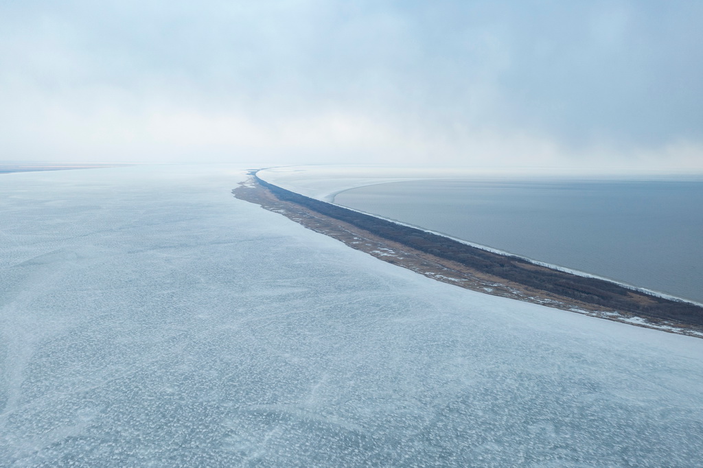 這是3月31日拍攝的部分湖面仍處于冰封狀態的興凱湖（無人機照片）。