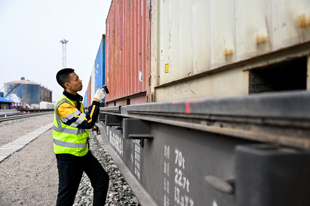 4月3日，在呼和浩特市新暢鐵路專用線，工作人員在巡檢鐵海聯運“一單制”運輸專列上的集裝箱。