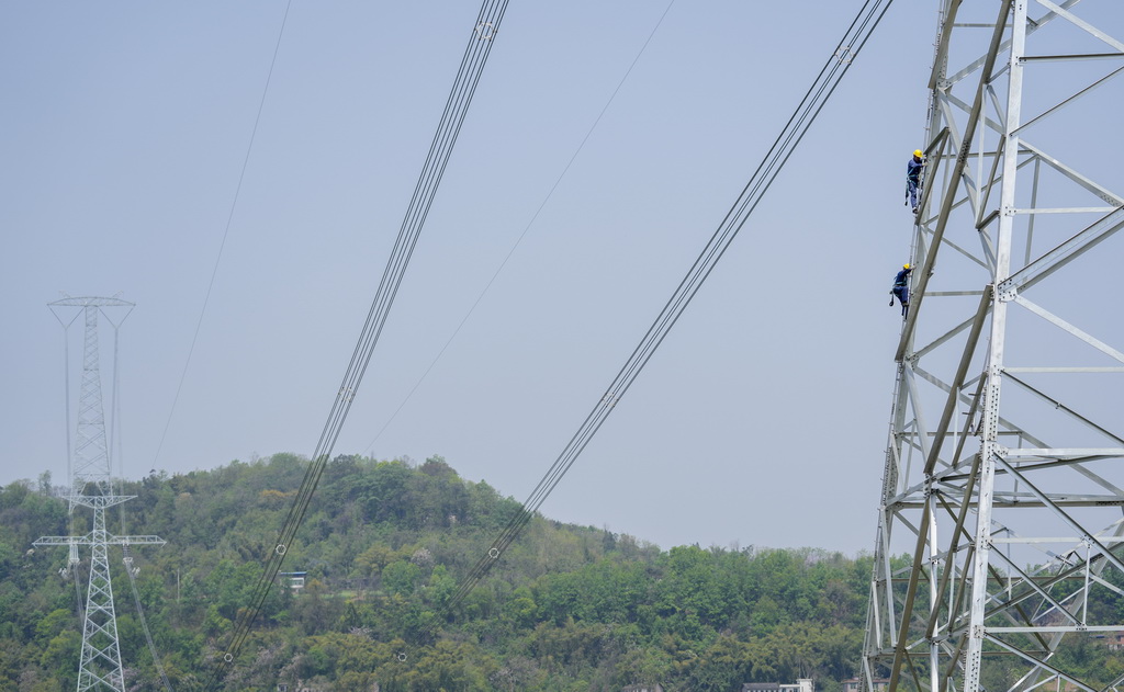 4月8日，在重慶市合川區，國網重慶超高壓公司工作人員登塔對“疆電入渝”特高壓工程重慶段開展走線驗收。新華社記者 劉潺 攝