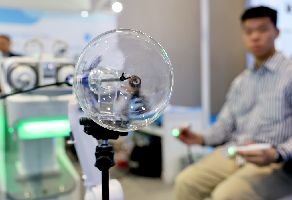 4月8日，工作人員在展會現場通過智能筆對一個全柔性微型內鏡手術機器人進行操控演示。