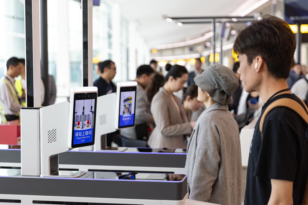 4月9日，旅客在重慶江北國際機場T3B航站樓排隊通過自助閘機登機。