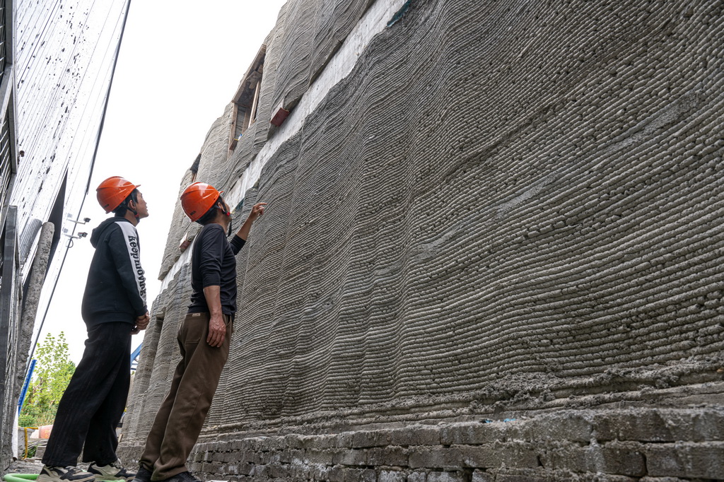 4月9日，研發人員在3D打印機建設的雙層小樓前進行查看。新華社記者 肖藝九 攝