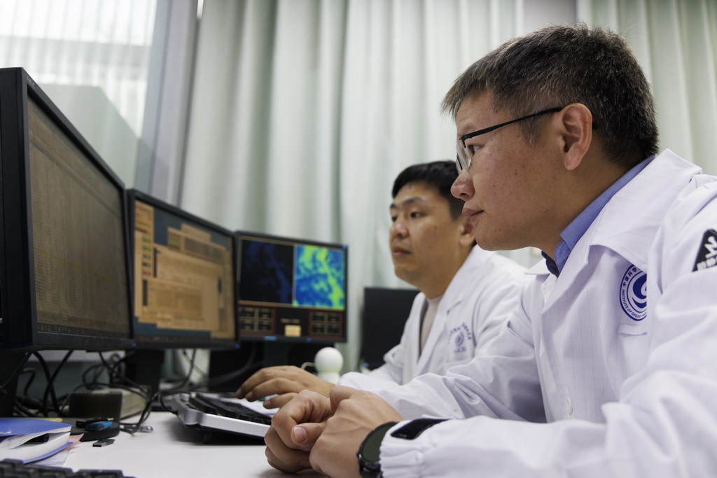 4月8日，在中國科學院地質與地球物理研究所納米離子探針實驗室，胡森研究員（前）、郝佳龍高級工程師觀察月球樣品檢測數據。