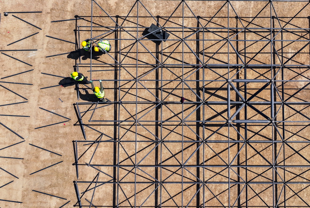 4月10日，工人在烏瑪高速惠農至石嘴山段施工現場安裝收費站頂棚（無人機照片）。