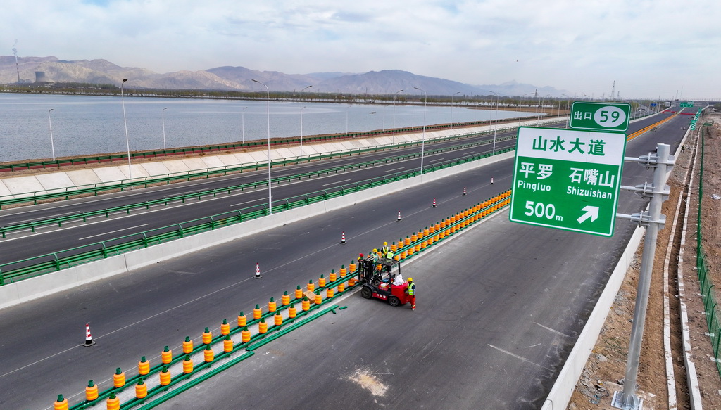 4月10日，工人在烏瑪高速惠農至石嘴山段施工現場安裝護欄（無人機照片）。