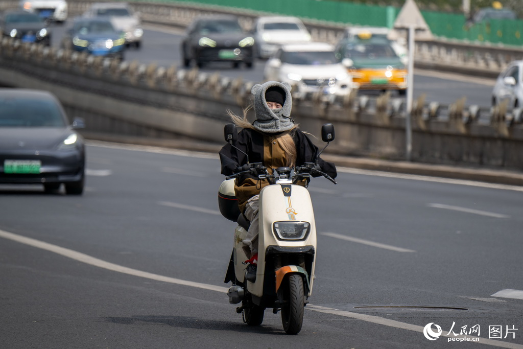 4月12日，北京建國路，市民全副武裝在大風中騎行。人民網記者 翁奇羽攝